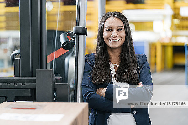 Confident woman standing in logistics center  with arms crossed