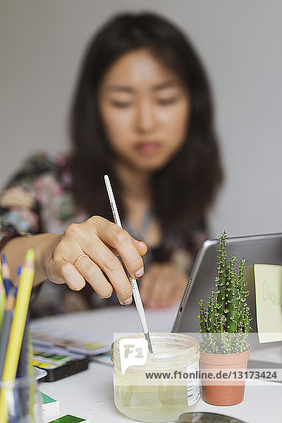 Illustratorin malt am Schreibtisch in einem Atelier  Nahaufnahme