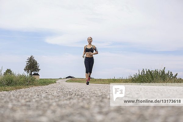 Reife Frau rennt im Sommer auf abgelegenem Feldweg