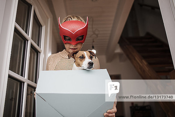 Junge mit Superhelden-Maske mit Jack Russel Terrier in