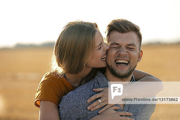 Glückliches verspieltes junges Paar in ländlicher Landschaft
