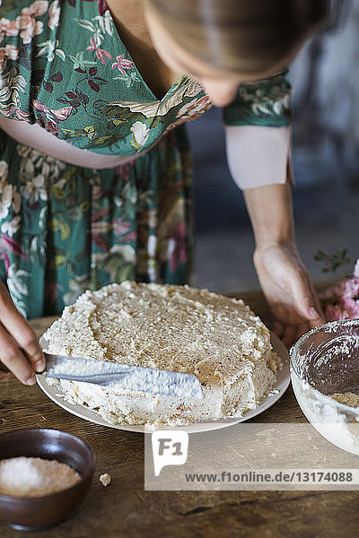 Junge Frau bereitet selbstgebackenen Kuchen zu