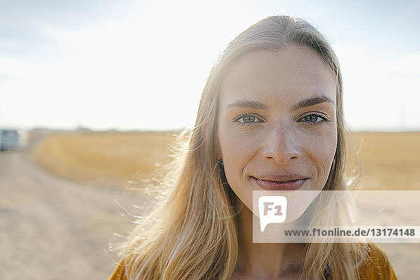 Porträt einer lächelnden jungen Frau in ländlicher Landschaft