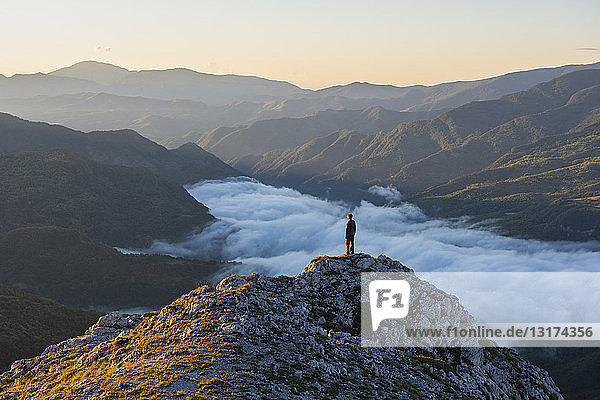 Italy  Umbria  Sibillini National Park  hiker standing on viewpoint at sunrise