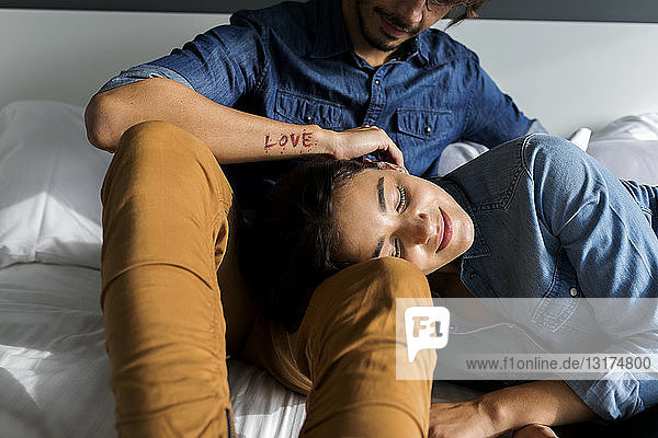Tattooed man cuddling up with girlfriend