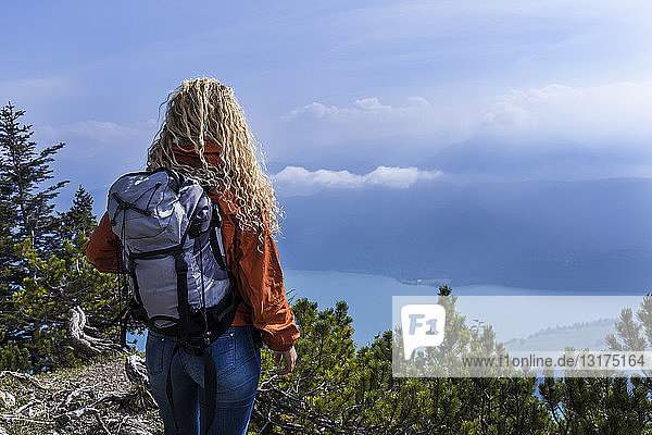 Junge Frau wandert in den bayerischen Bergen mit Blick auf den Walchensee