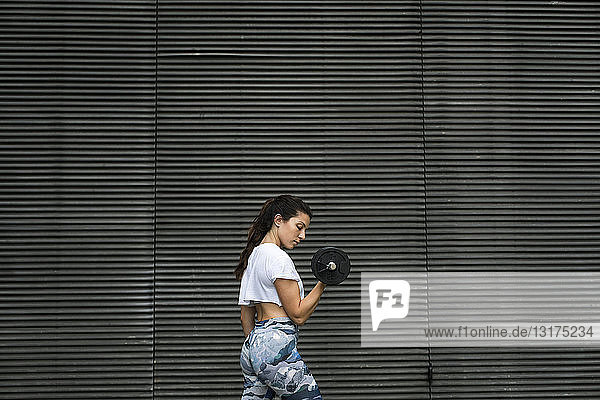 Junge Frau beim Krafttraining im Freien