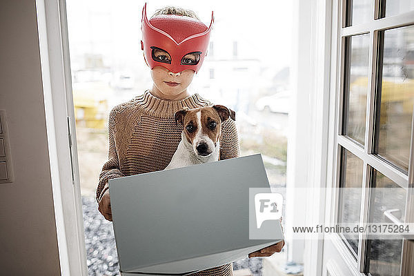 Portrait of boy wearing Superhero mask with Jack Russel Terrier in