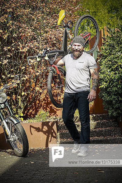 Portrait of man switching from motorbike to bicycle