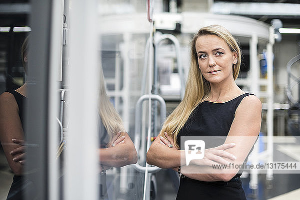 Porträt einer selbstbewussten Frau in einer Fabrikhalle