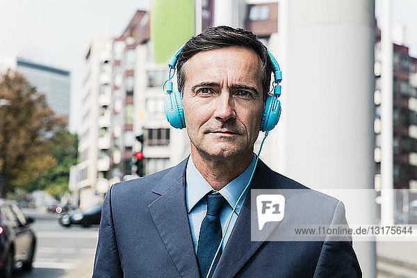 Porträt eines Geschäftsmannes mit Kopfhörern in der Stadt