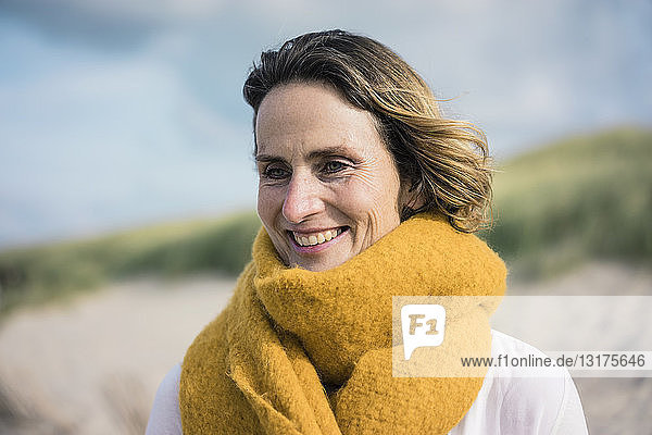 Mature woman relaxing in the dunes  enjoying the wind