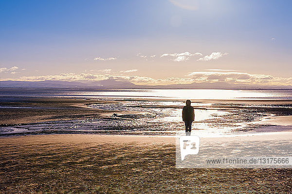Großbritannien  Schottland  Solway Firth  Silhouette einer am Strand stehenden Touristin