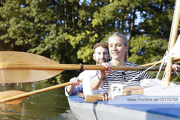 Junges Paar geniesst eine Kanufahrt auf einem See