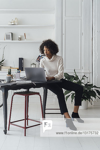 Mid adult woman working in her home office  using laptop
