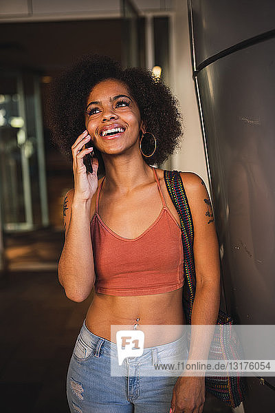 Porträt einer glücklichen jungen Frau am Handy
