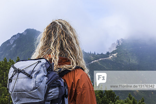 Junge Frau wandert in den bayerischen Bergen mit Blick auf den Walchensee