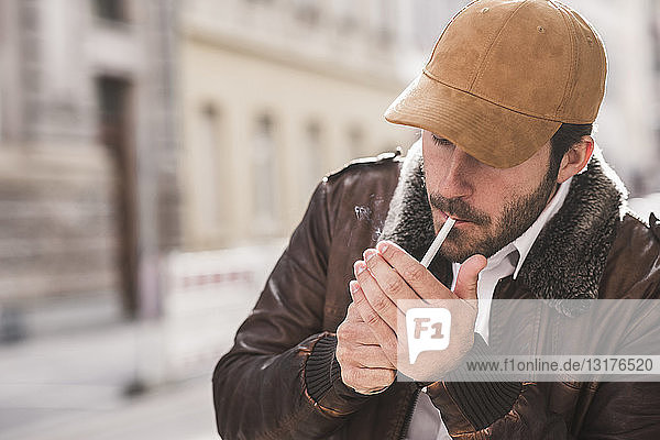 Mann zündet Zigarette an