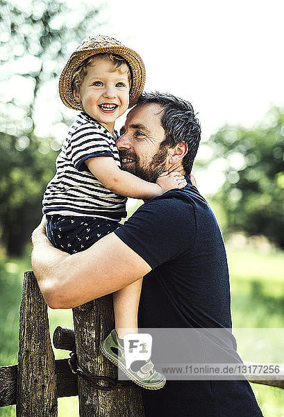 Porträt eines glücklichen Vaters und eines kleinen Sohnes  die zusammen Zeit im Freien verbringen