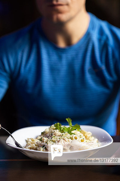 Close-up of athlete eating pasta dish