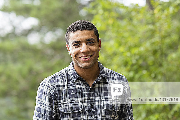 Porträt eines lächelnden jungen Mannes im Freien