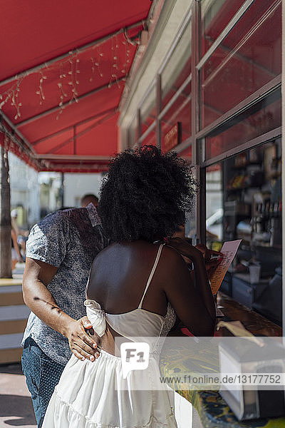 Junges Paar wählt an einem Kiosk aus der Speisekarte