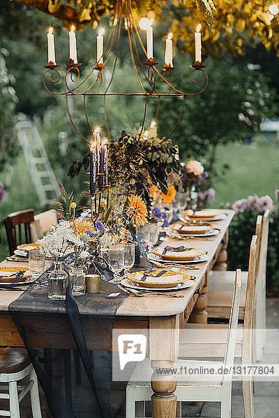 Festlich gedeckter Tisch mit Kerzen im Freien