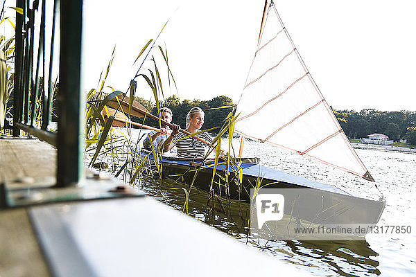 Junges Paar geniesst eine Kanufahrt mit Segeln auf einem See