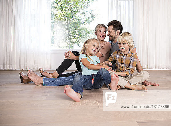 Entspannte Familie  die zu Hause auf dem Boden sitzt