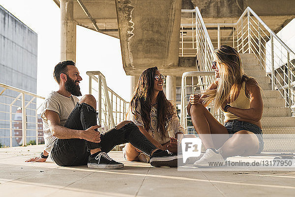 Freunde mit Skateboard sitzen entspannt in der Stadt