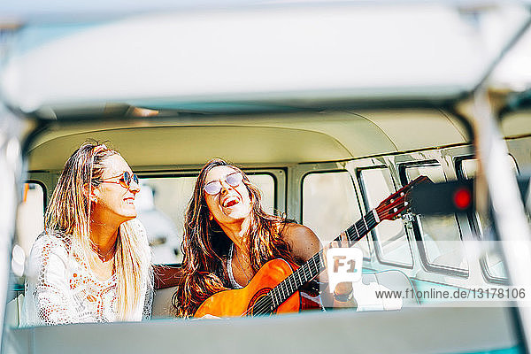 Lesbian couple doing a road trip  singing and laughing in their van
