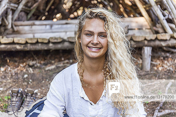 Porträt einer lächelnden jungen Frau in einer Holzunterkunft