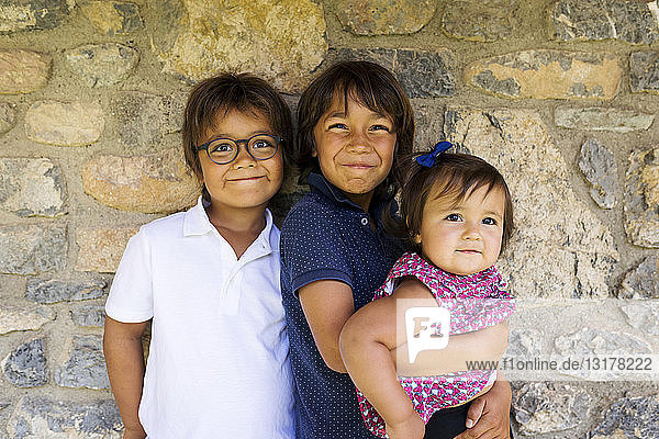 Porträt von zwei lächelnden Jungen und einem kleinen Mädchen