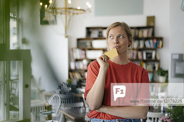 Junge Frau mit Karte in einem Cafe beim Denken