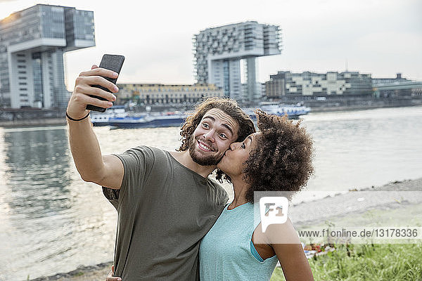 Deutschland  Köln  glückliches Paar beim Egoismus am Flussufer