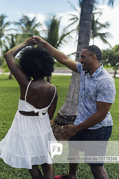 USA  Florida  Miami Beach  happy young couple dancing in a park in summer