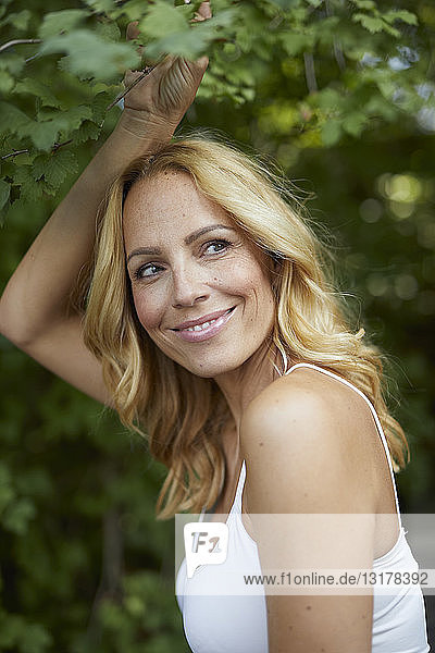 Porträt einer lächelnden blonden Frau im Freien