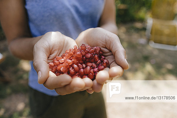 Woman's hands holding pomegranate seeds
