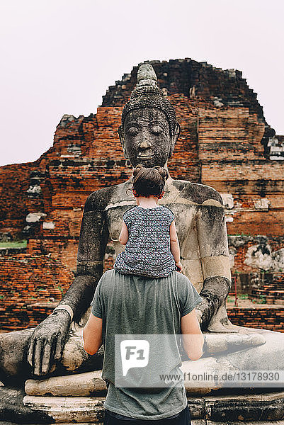 Thailand  Ayutthaya  Vater und Tochter betrachten eine Buddha-Statue im Wat Mahathat