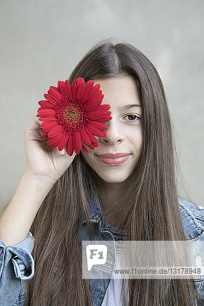 Bildnis eines lächelnden Mädchens mit Blumenkopf aus roter Gerbera