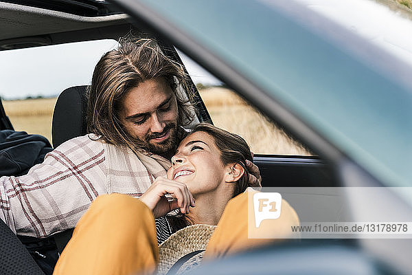 Happy affectionate young couple in a car