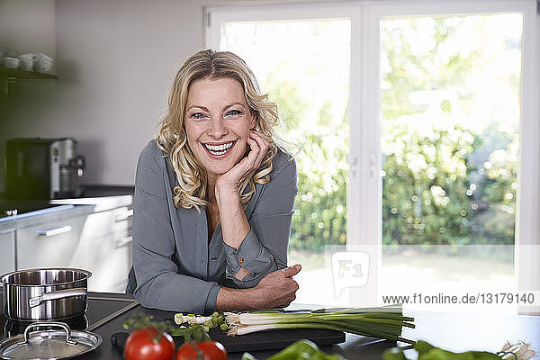 Porträt einer glücklichen Frau beim Kochen in der Küche