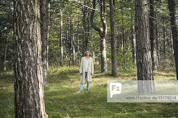 Serene woman standing in the forest