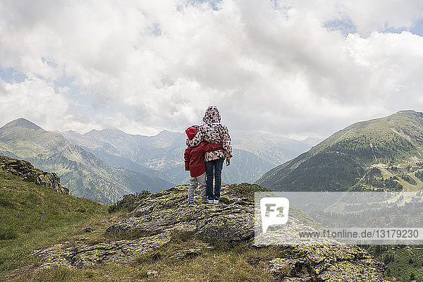 Andorra  Ordino  junges Mädchen und ihr Bruder  Arm um Arm  auf Aussichtspunkt im Berg stehend