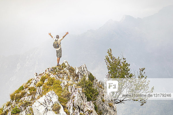 Italy  Massa  man cheering on top of a peak in the Alpi Apuane mountains