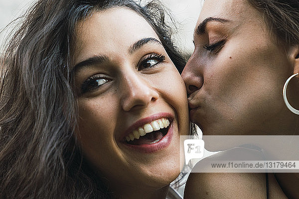 Young woman kissing her best friend
