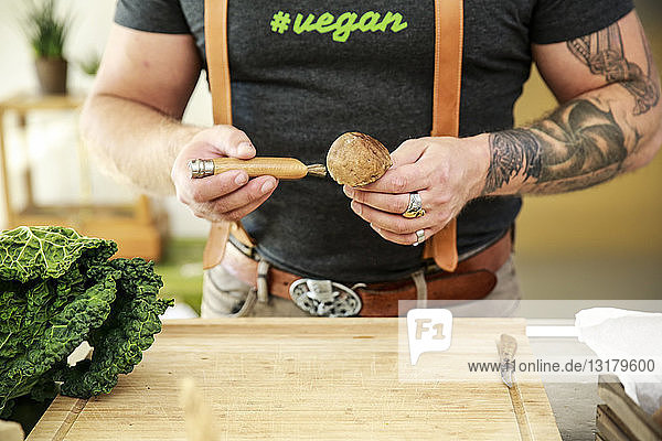 Veganer reinigt Pilze in seiner Küche