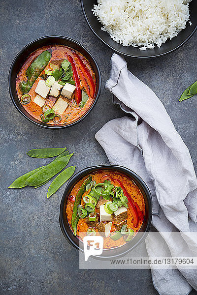 Zwei Schüsseln rotes Thai-Curry mit Zuckerschoten  Karotten  Paprika  Frühlingszwiebeln und geräuchertem Tofu