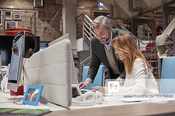 Businessman and woman working together in modern office