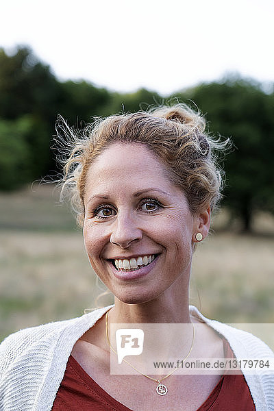 Porträt einer lächelnden Frau in der Natur